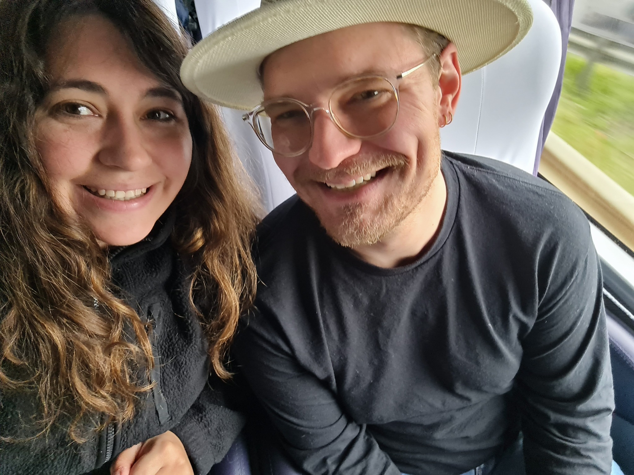 Trini and Tyler smiling together while traveling